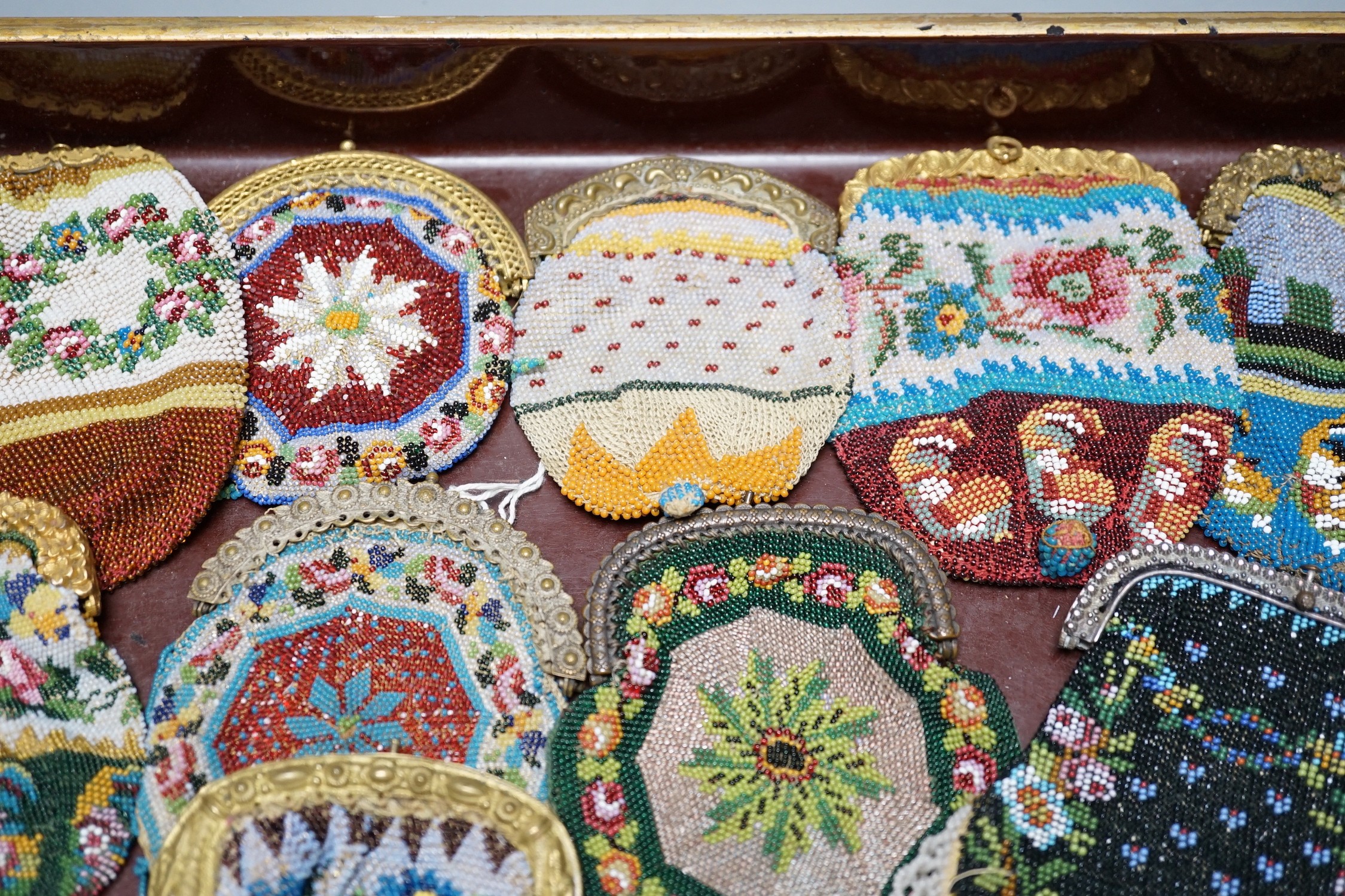 Twenty mid-19th century Berlin beadwork purses with gilt-metal frames, largest 10cm